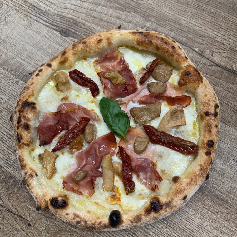 Pizza Parma con crudo, pomodori secchi, carciofi e basilico